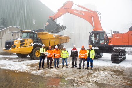 Gruppenbild Übergabe Hitachi ZX890‑7 mit Locmaster Gewinnungslöffel und Bell B45E