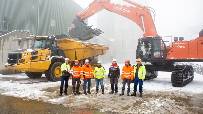 Gruppenbild Übergabe Hitachi ZX890‑7 mit Locmaster Gewinnungslöffel und Bell B45E